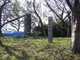 黒崎城址の石碑とその左に建築資材（ブルーシート部分）